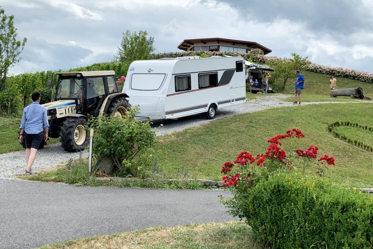 Auf dem Weingut Eibel ist die Auffahrt zur geplanten Location etwas knifflig. Der Winzer packt selbst mit an und zieht unseren Wohnwagen mit dem Traktor auf den gewünschten Platz. 